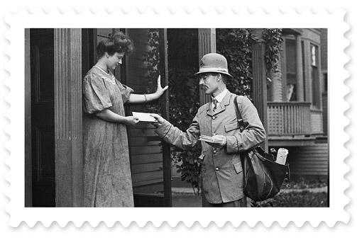 A black-and-white 19th century photograph of a postal worker delivering a letter to a young woman holding a door open.