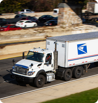A truck and trailer with the USPS logo on the trailer.